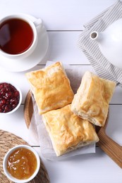 Delicious puff pastry served on white wooden table, flat lay