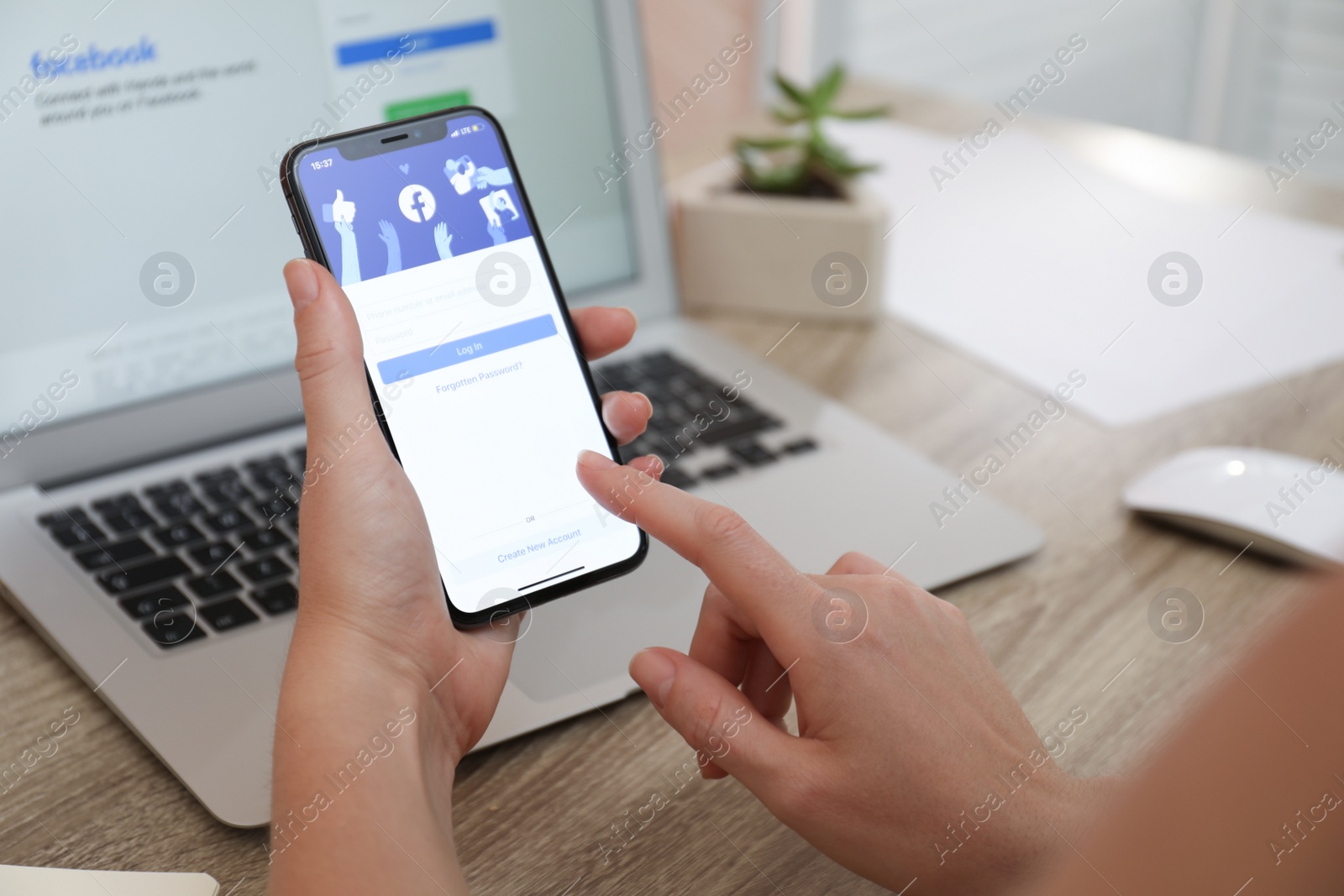 Photo of MYKOLAIV, UKRAINE - AUGUST 28, 2020: Woman holding iPhone 11 with Facebook app on screen at table, closeup