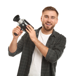 Young man with vintage video camera on white background