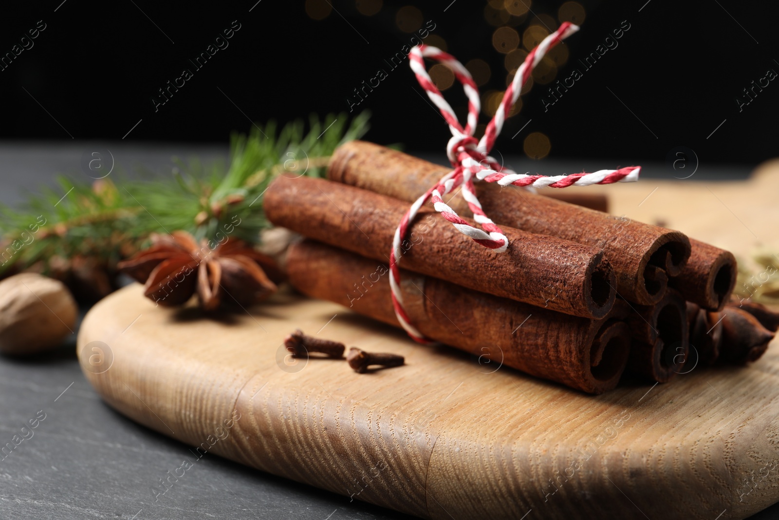 Photo of Cinnamon sticks and other spices on gray table, closeup
