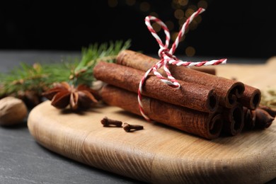 Cinnamon sticks and other spices on gray table, closeup