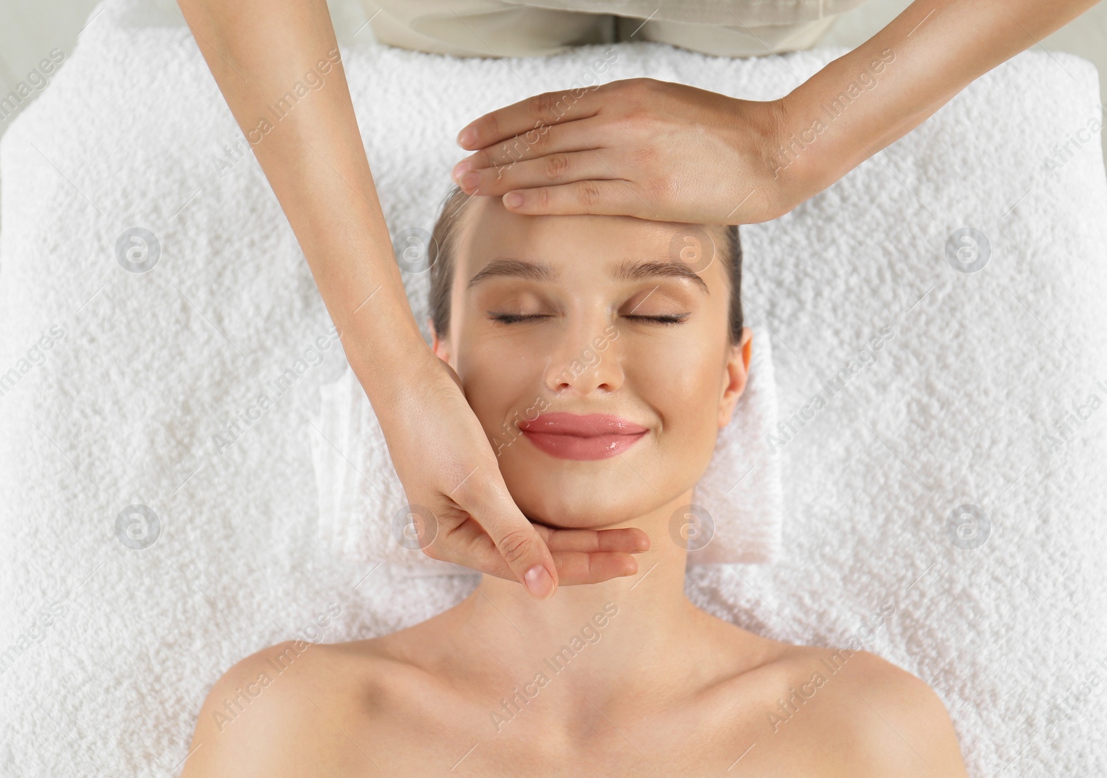 Photo of Beautiful young woman enjoying massage in spa salon, top view