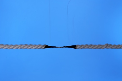 Burning rope at breaking point on color background