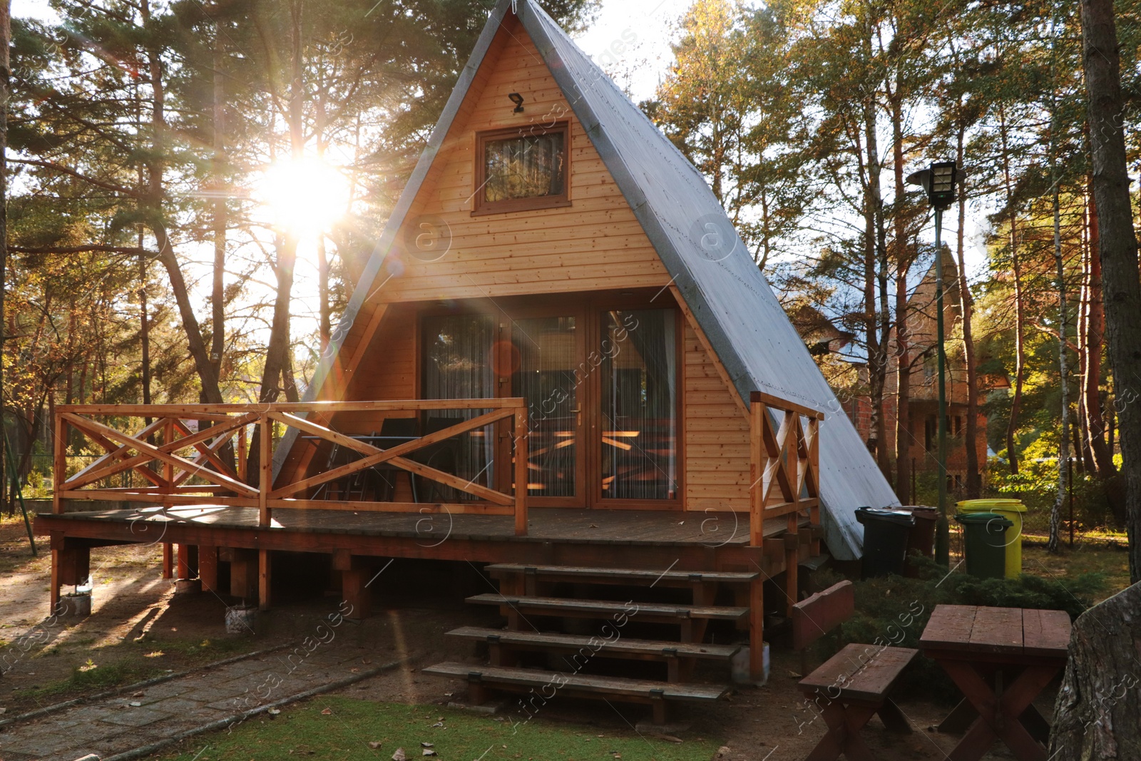 Photo of Picturesque view of modern wooden house with veranda near forest on sunny day