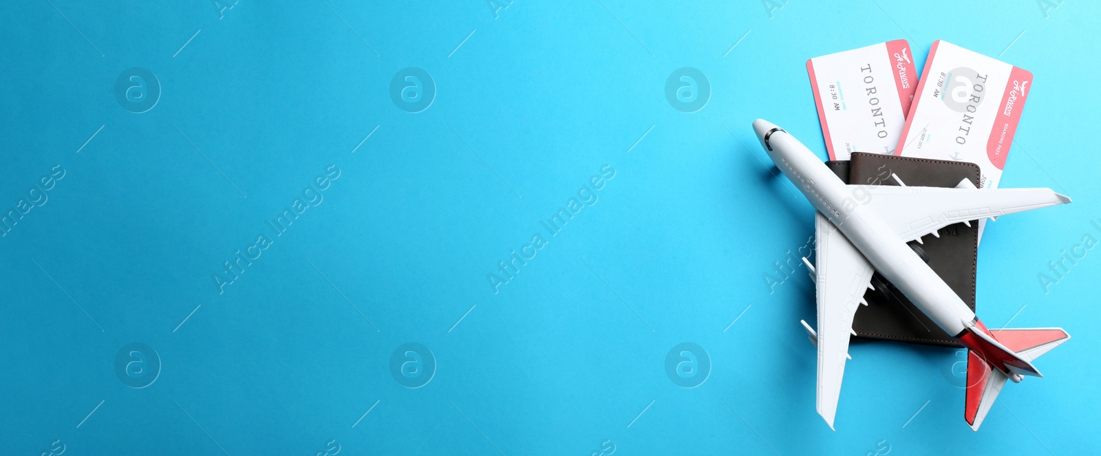 Photo of Toy airplane and passports with tickets on light blue background, flat lay. Space for text