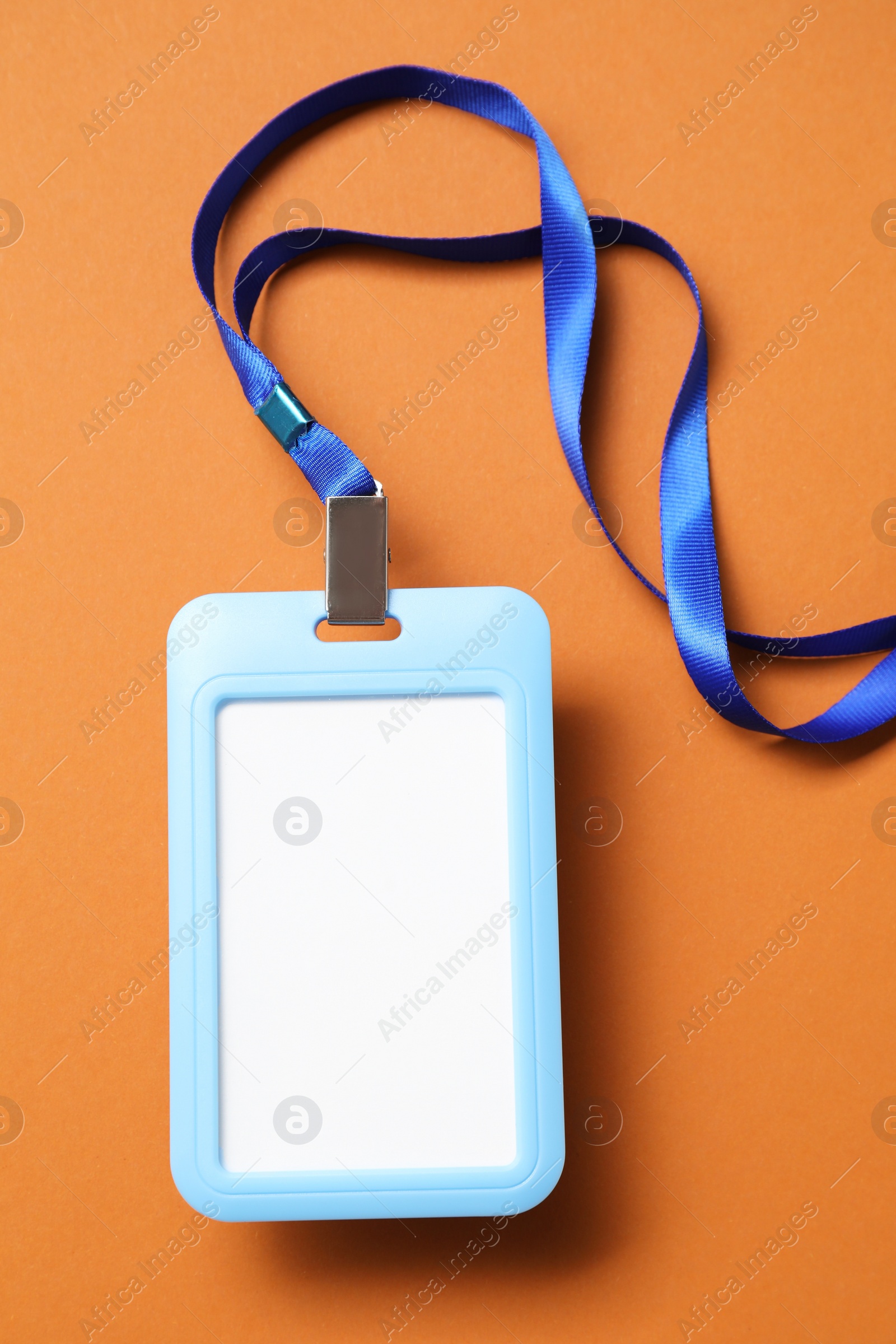 Photo of Blank badge with string on orange background, top view