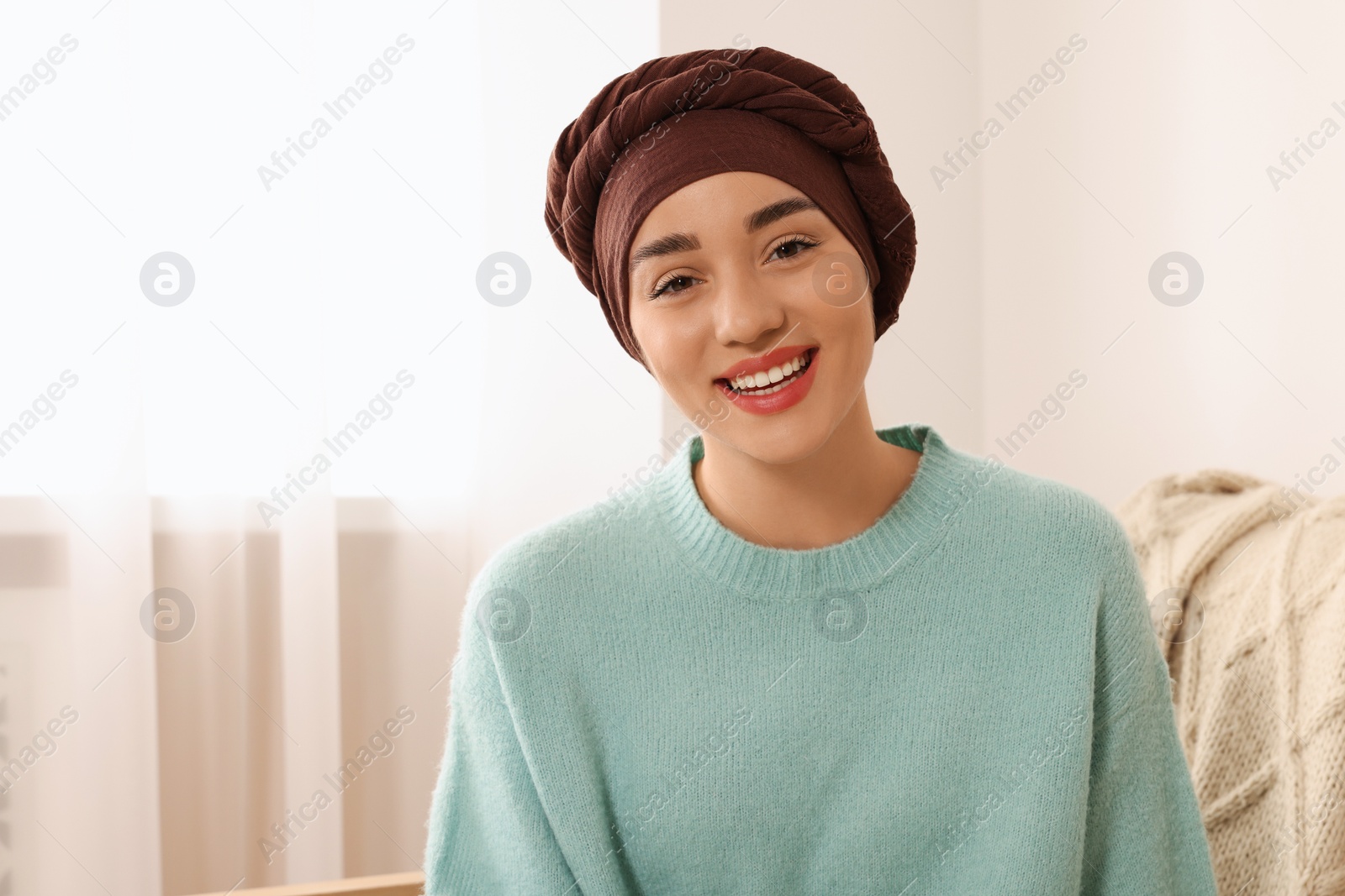 Photo of Cancer patient. Young woman with headscarf near window indoors, space for text