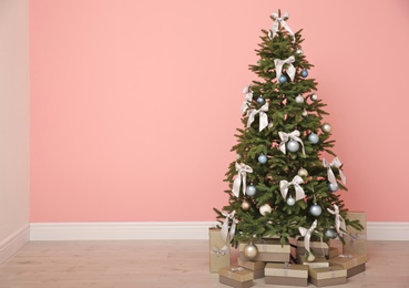 Photo of Decorated Christmas tree with gift boxes indoors