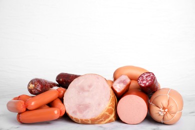 Photo of Different types of sausages on white marble table