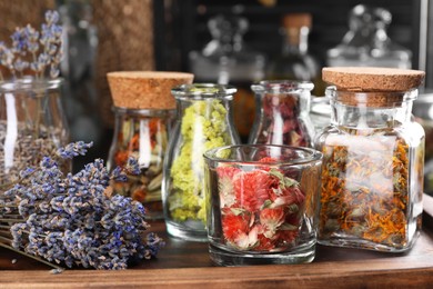 Many different herbs and dry lavender flowers on wooden board