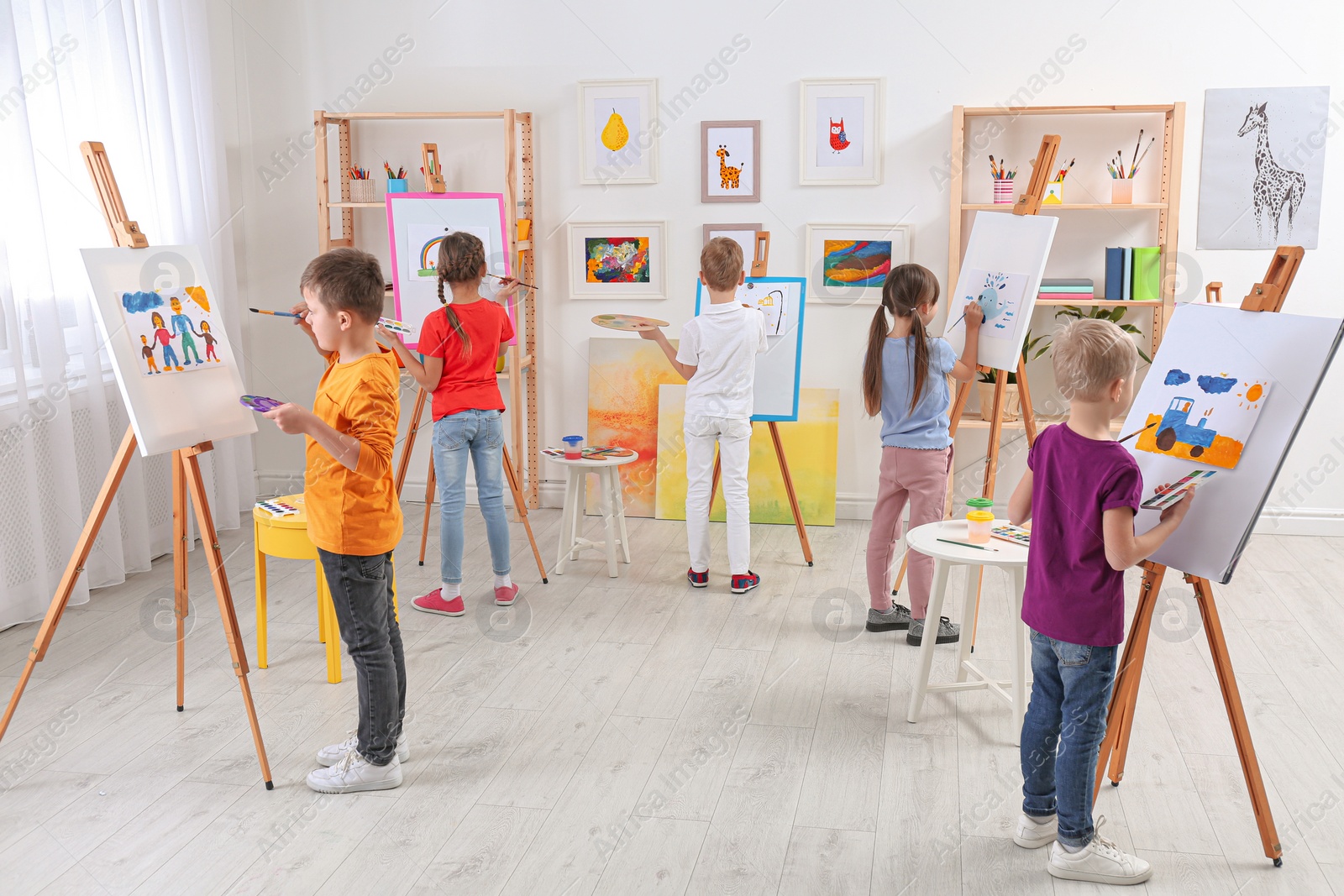 Photo of Cute little children painting during lesson in room