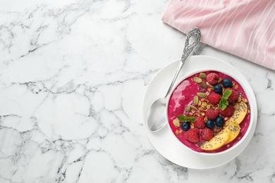 Photo of Delicious acai smoothie with granola and berries served on white marble table, flat lay. Space for text