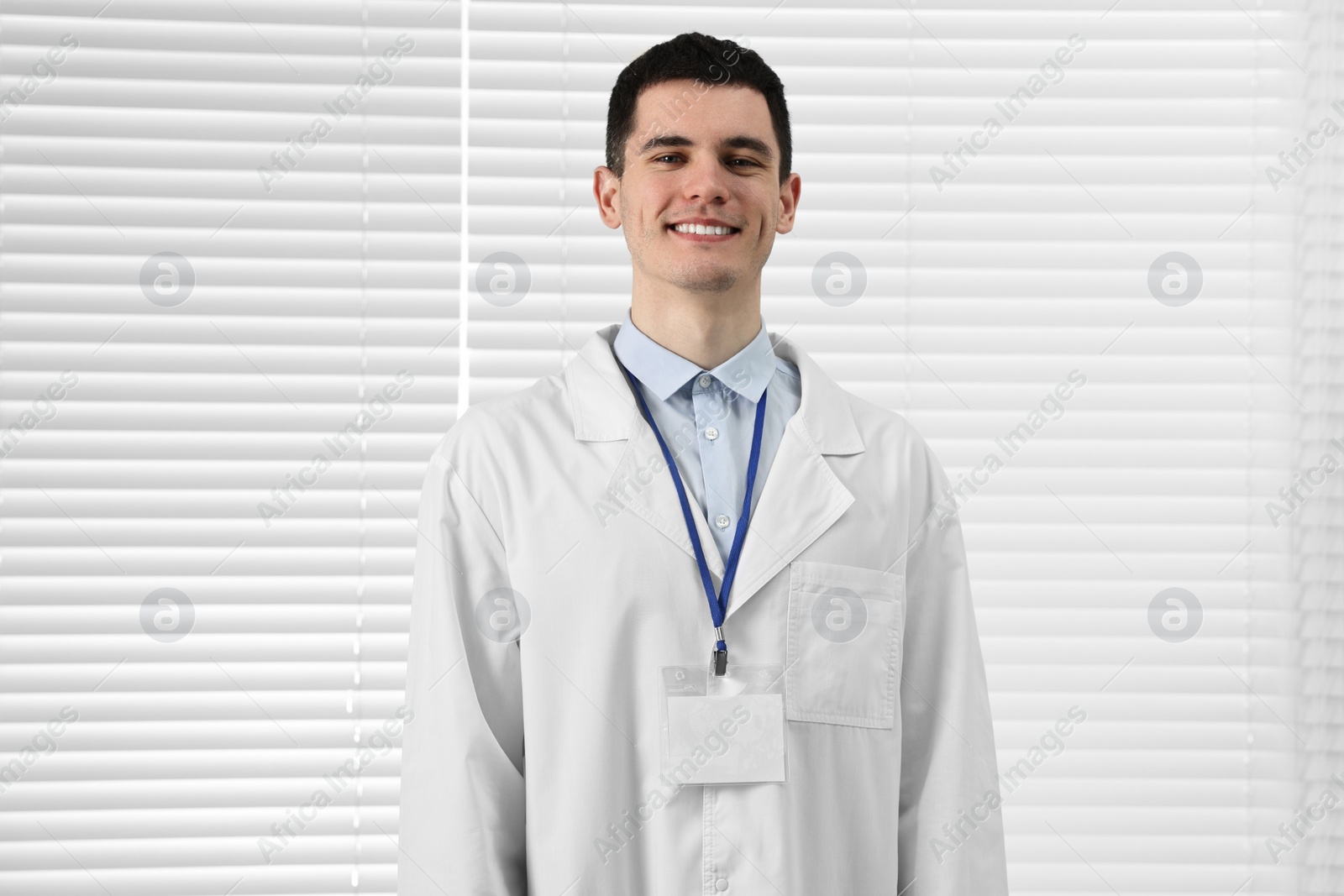 Photo of Smiling doctor with empty badge in hospital