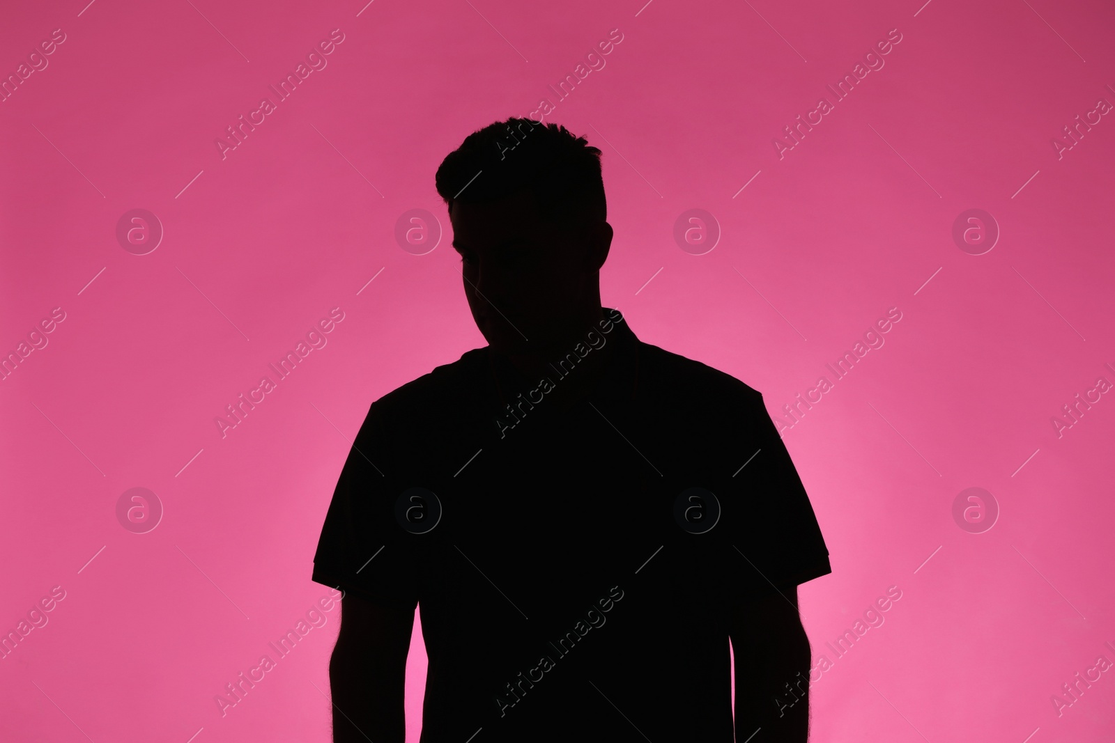 Photo of Silhouette of anonymous man on pink background