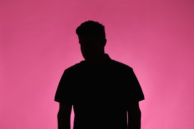 Photo of Silhouette of anonymous man on pink background