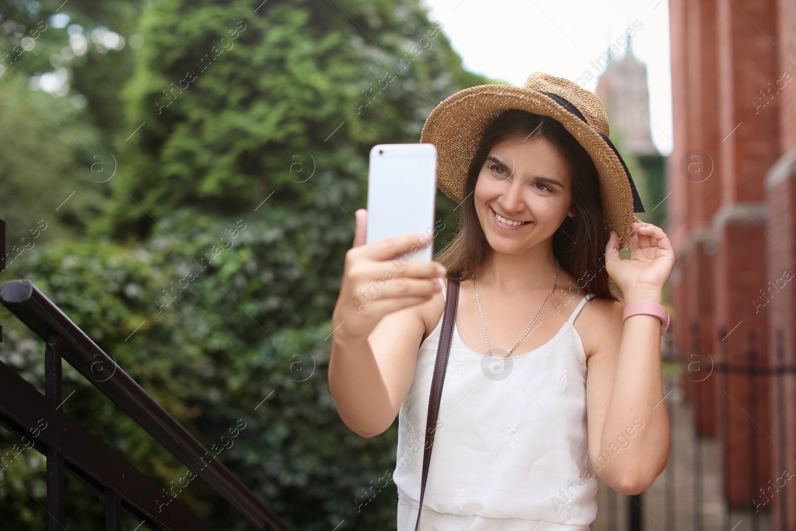 Photo of Young woman taking selfie on city street