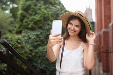 Young woman taking selfie on city street