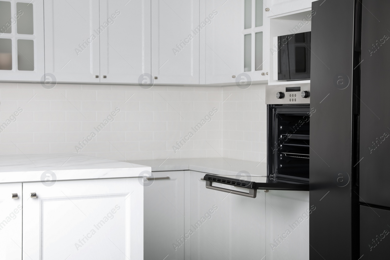 Photo of Modern oven and microwave in white clean kitchen