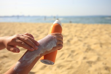 Photo of Child applying sunscreen near sea, closeup. Space for text. Sun protection care