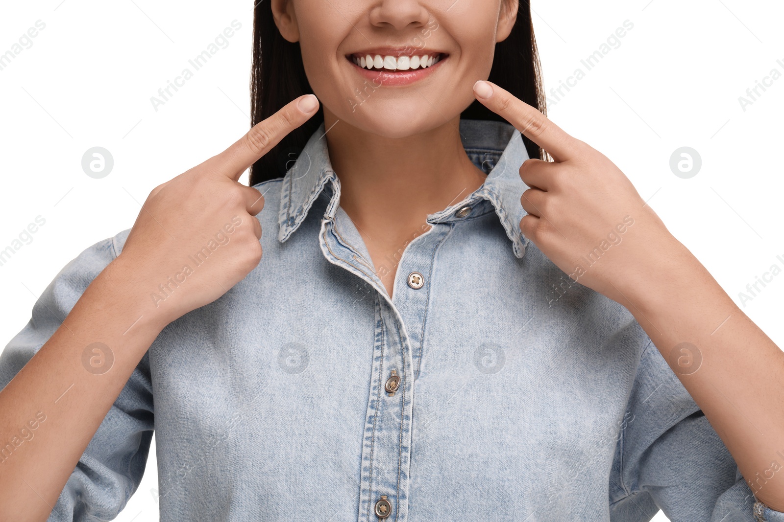 Photo of Woman pointing at her clean teeth and smiling on white background, closeup