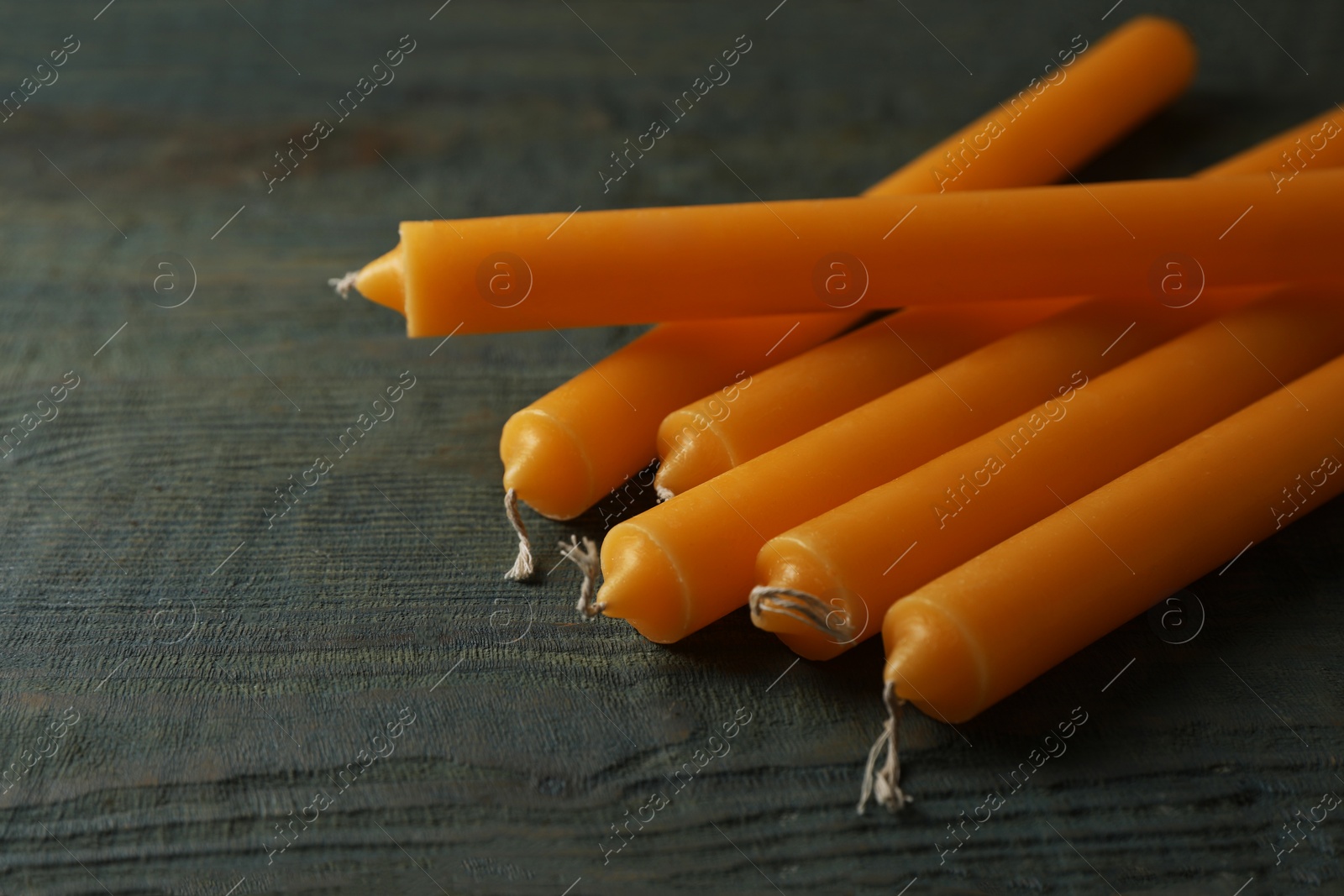 Photo of Many church wax candles on old wooden table, closeup. Space for text