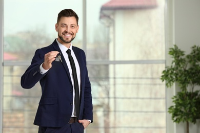 Photo of Real estate agent holding house key, indoors