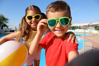 Photo of Happy children taking selfie near swimming pool. Summer vacation