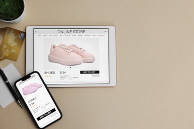 Photo of Online shopping. Flat lay composition with modern tablet and smartphone on beige background