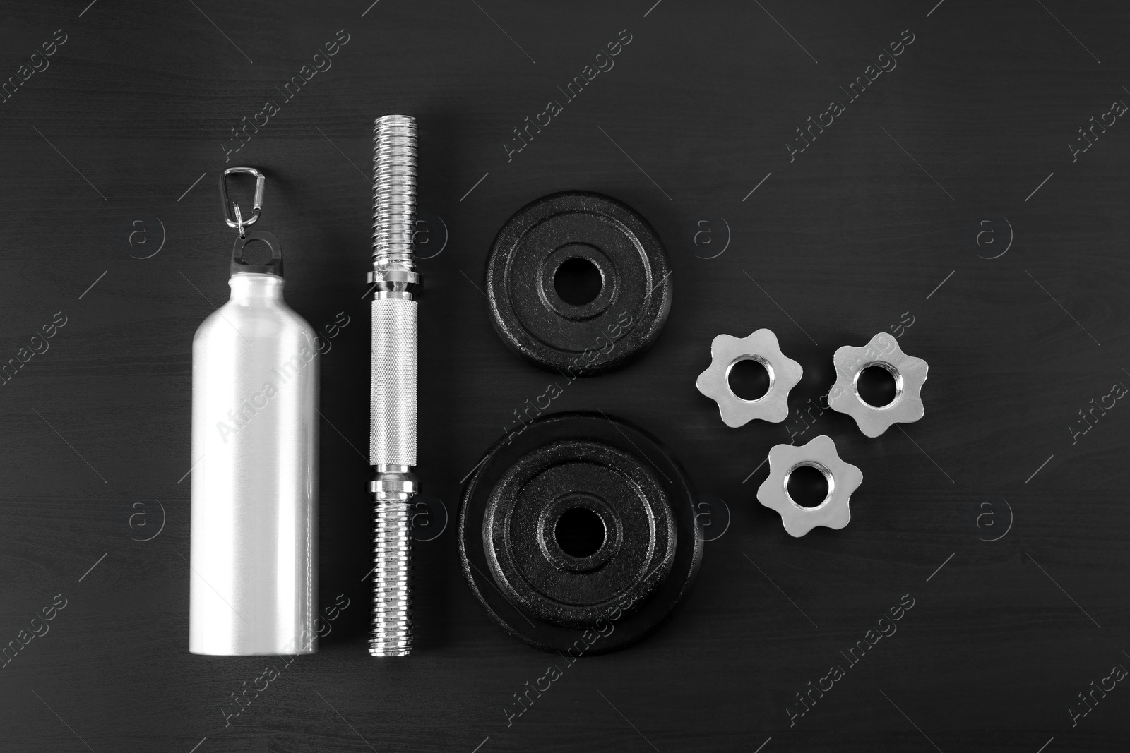 Photo of Flat lay composition with dumbbell parts on dark wooden background