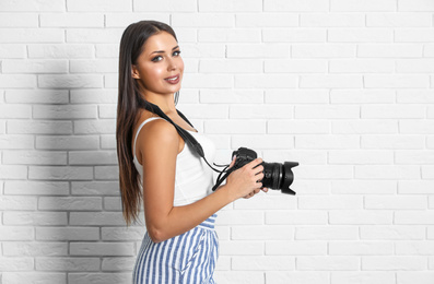 Professional photographer working near white brick wall in studio