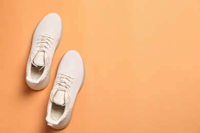 Photo of Pair of stylish sport shoes on orange background, flat lay. Space for text