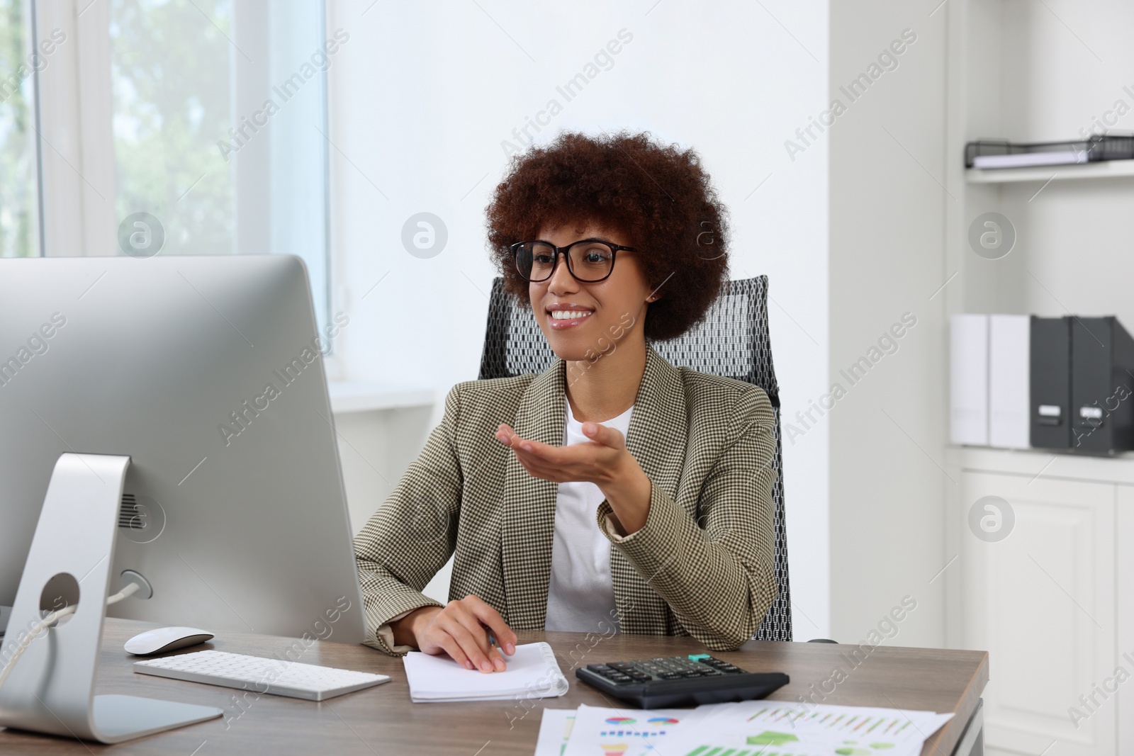 Photo of Professional accountant having video chat via computer at desk in office