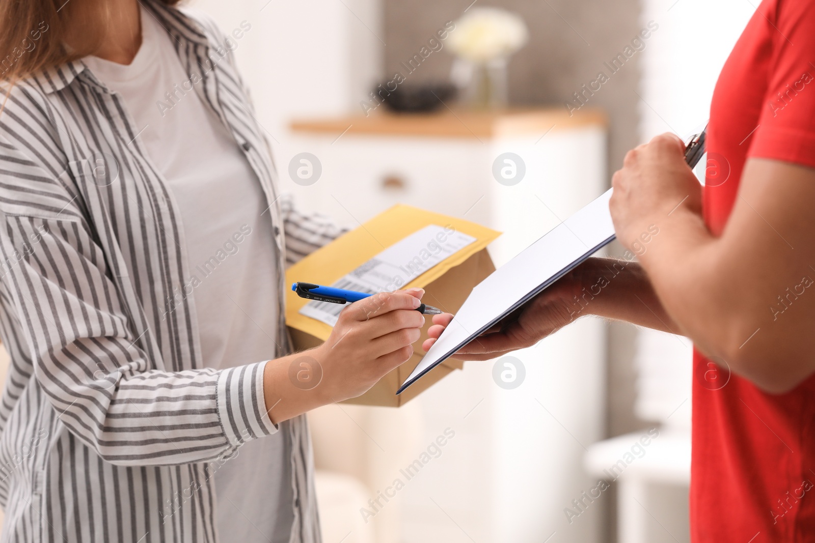 Photo of Woman signing for delivered parcels at home, closeup. Courier service