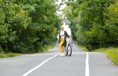 Photo of Beautiful woman in casual outfit with bicycle outdoors