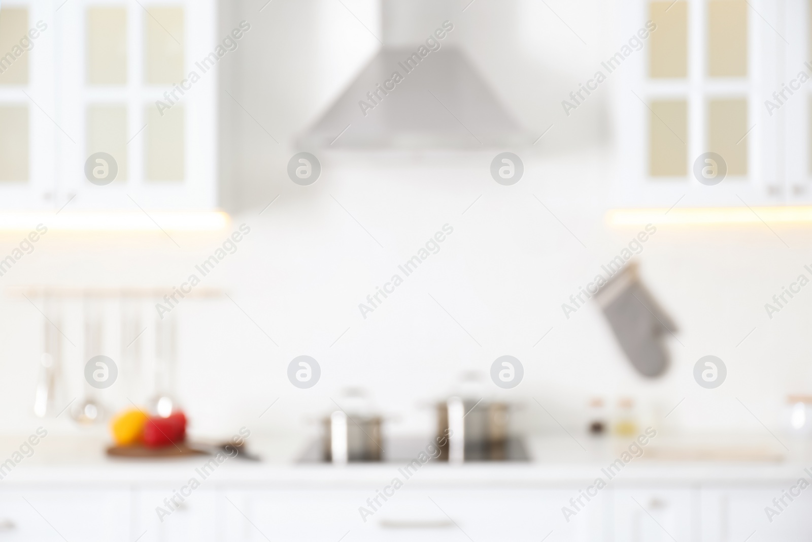 Photo of Blurred view of modern kitchen interior with white furniture