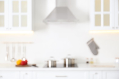 Photo of Blurred view of modern kitchen interior with white furniture