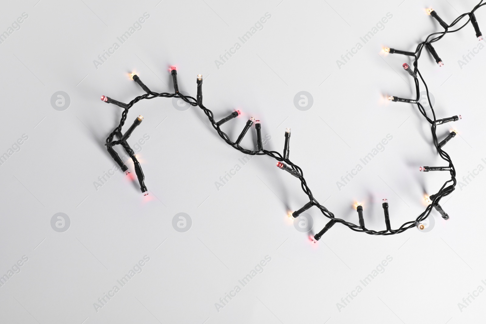 Photo of Beautiful Christmas lights on white background, top view