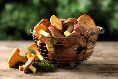 Photo of Different wild mushrooms on wooden table, closeup