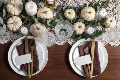 Photo of Beautiful autumn table setting. Plates, cutlery, glasses, blank cards and floral decor, flat lay