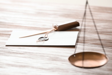 Document with notary seal and letter opener on wooden table