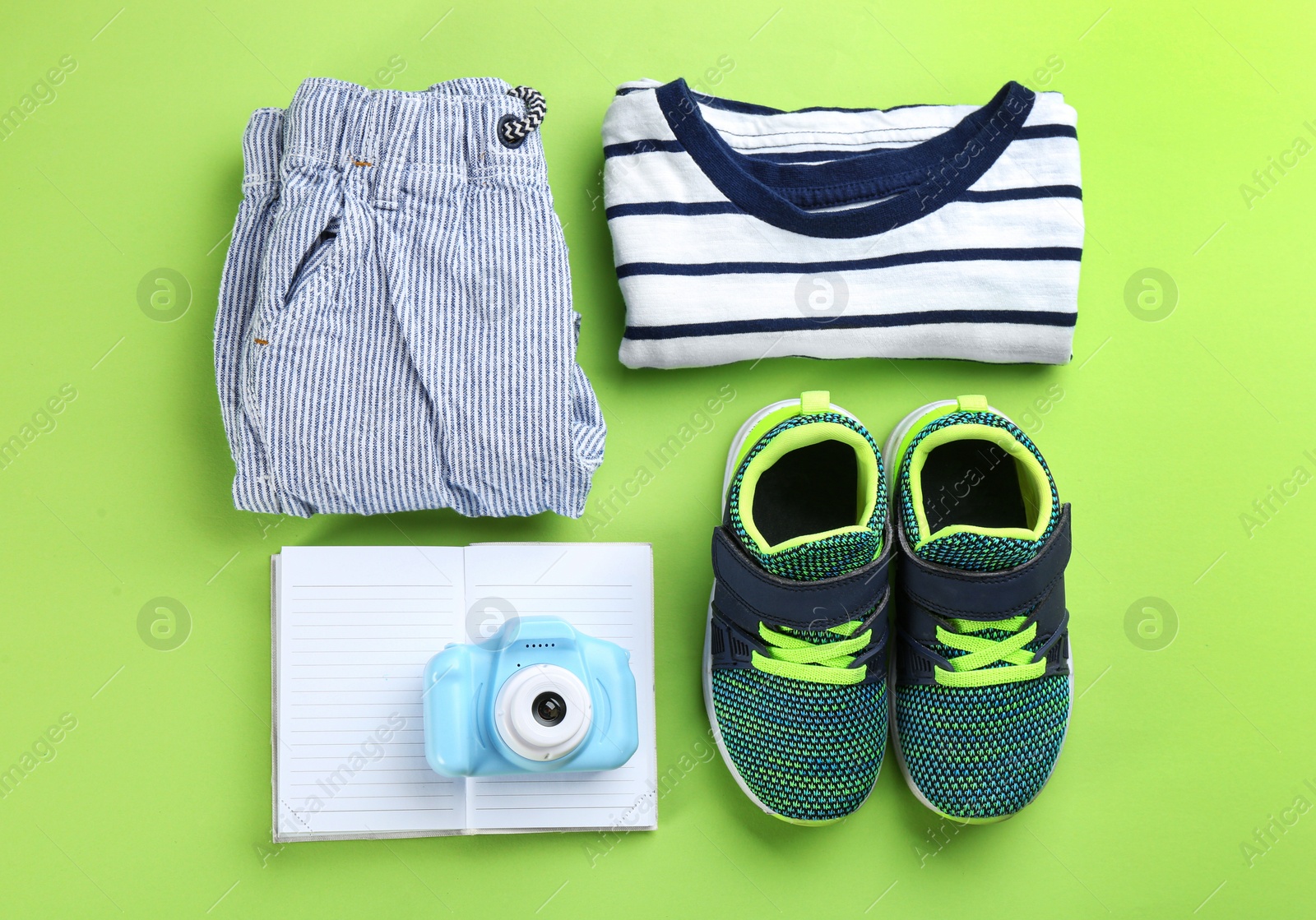 Photo of Flat lay composition with little photographer's toy camera on light green background