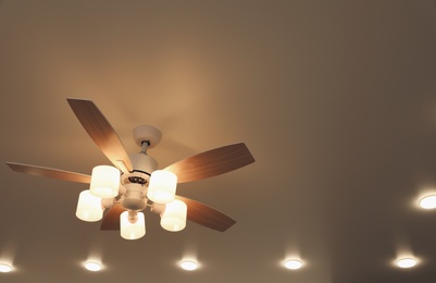 Photo of Modern ceiling fan with lamps indoors, below view