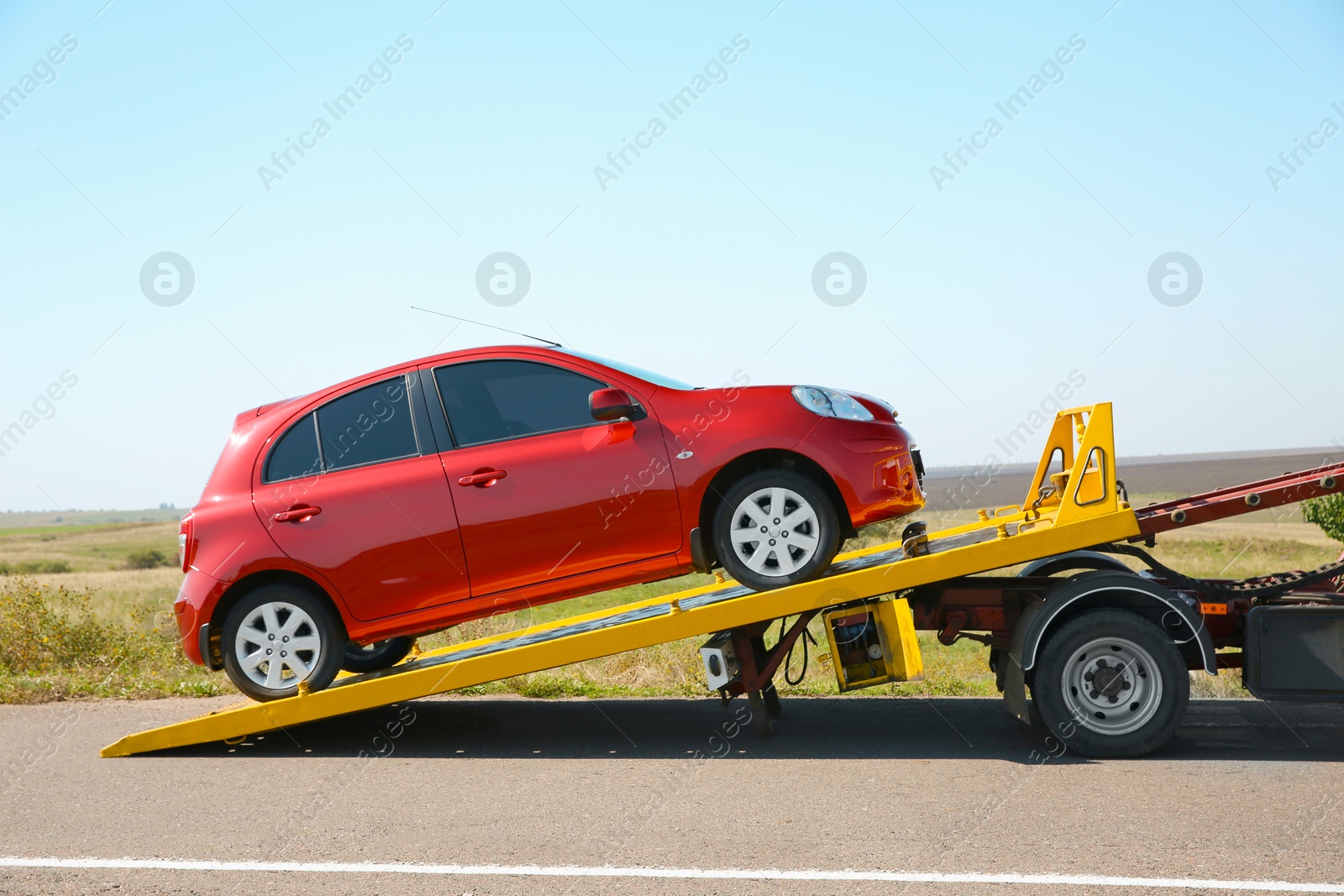 Photo of Tow truck with broken car on country road