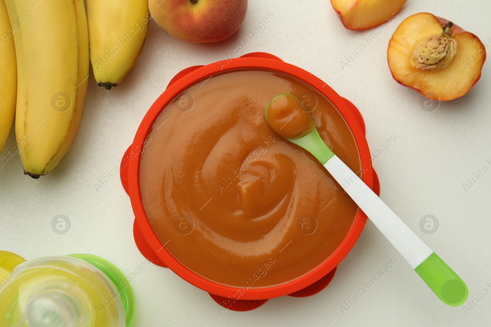 Photo of Tasty pureed baby food and ingredients on white table, flat lay