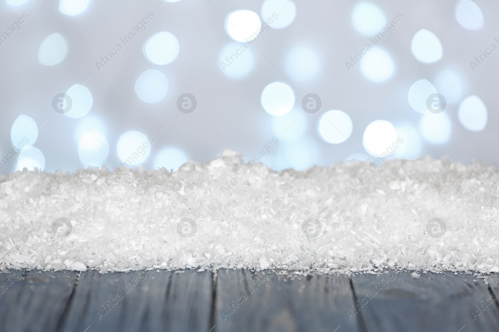 Photo of Heap of snow on wooden surface against blurred background. Christmas season