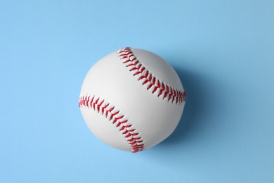 One baseball ball on light blue background, top view