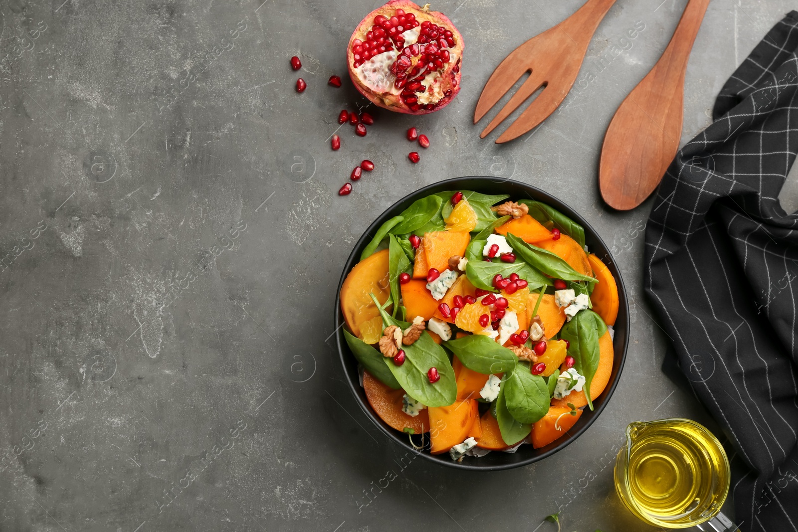 Photo of Delicious persimmon salad served on grey table, flat lay. Space for text