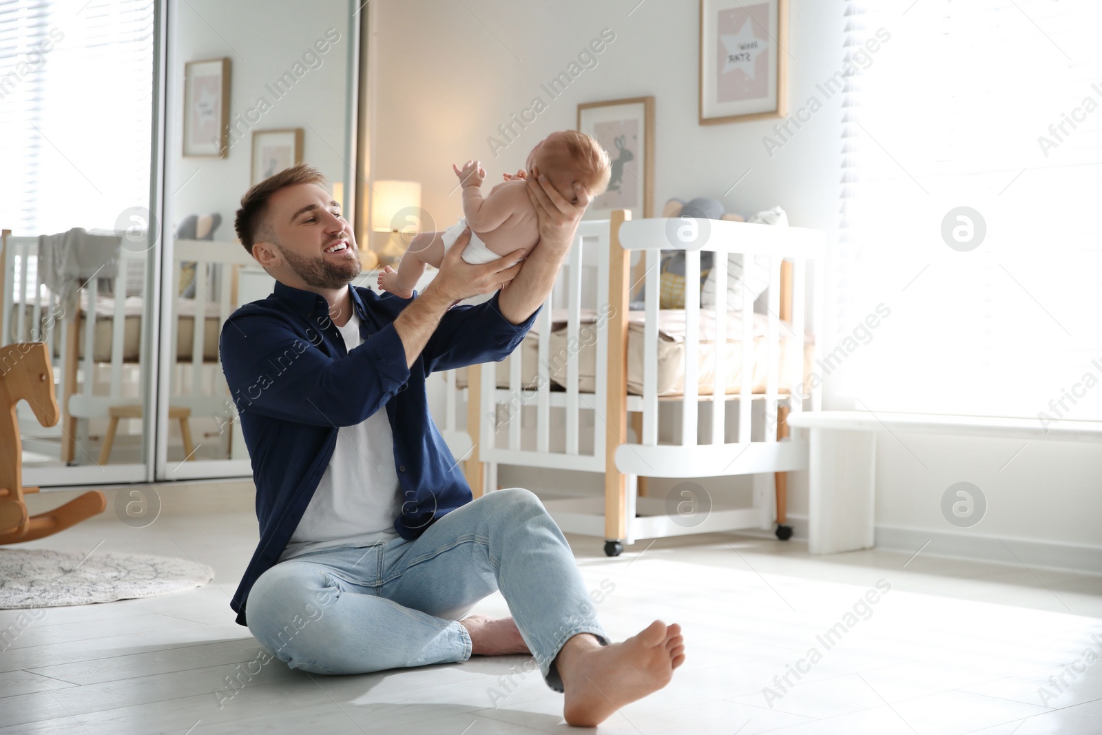 Photo of Father with his newborn son at home