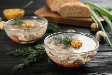 Photo of Delicious aspic with meat served on black wooden table