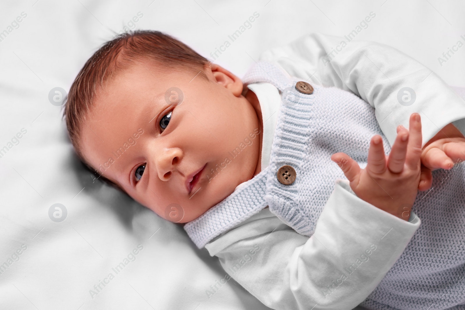 Photo of Cute newborn baby lying on white blanket